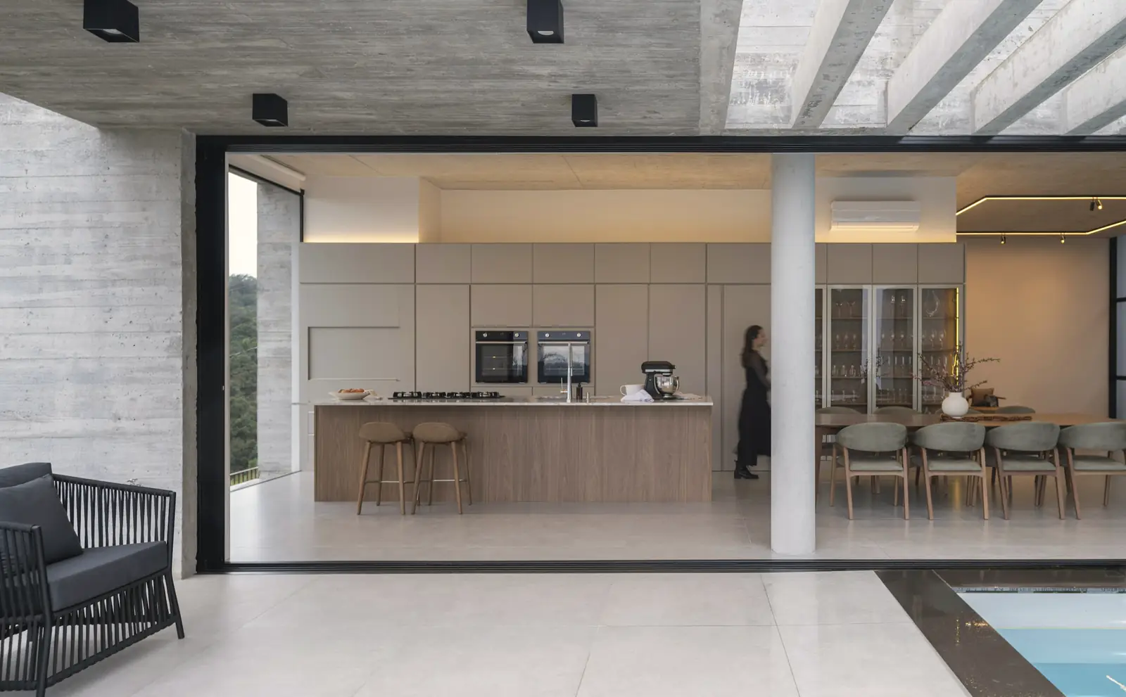 A finished open-plan kitchen with a long island and a wall of glass onto the garden