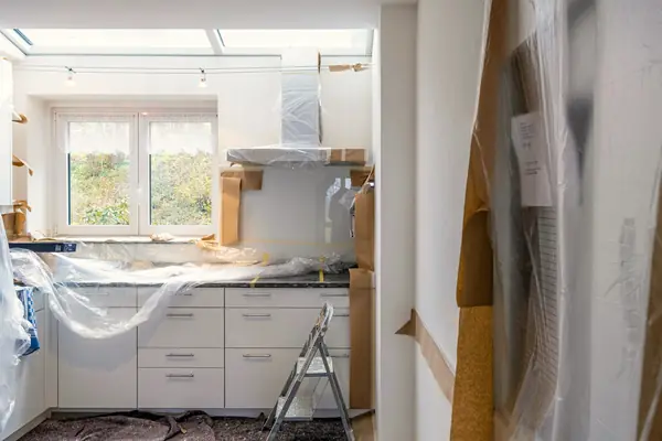 A new kitchen being fitted, units still wrapped in protective film