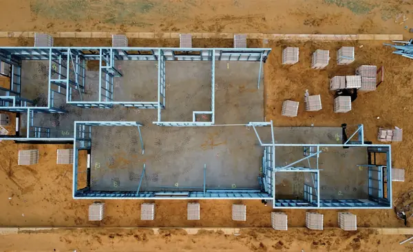 Aerial view of a house's ground-floor walls set out on a cleared plot